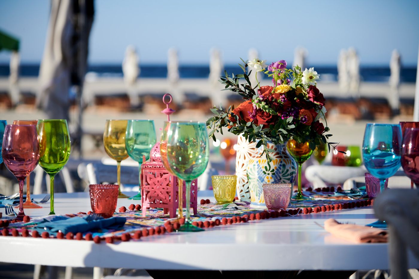 Colored glassware on a beachfront table