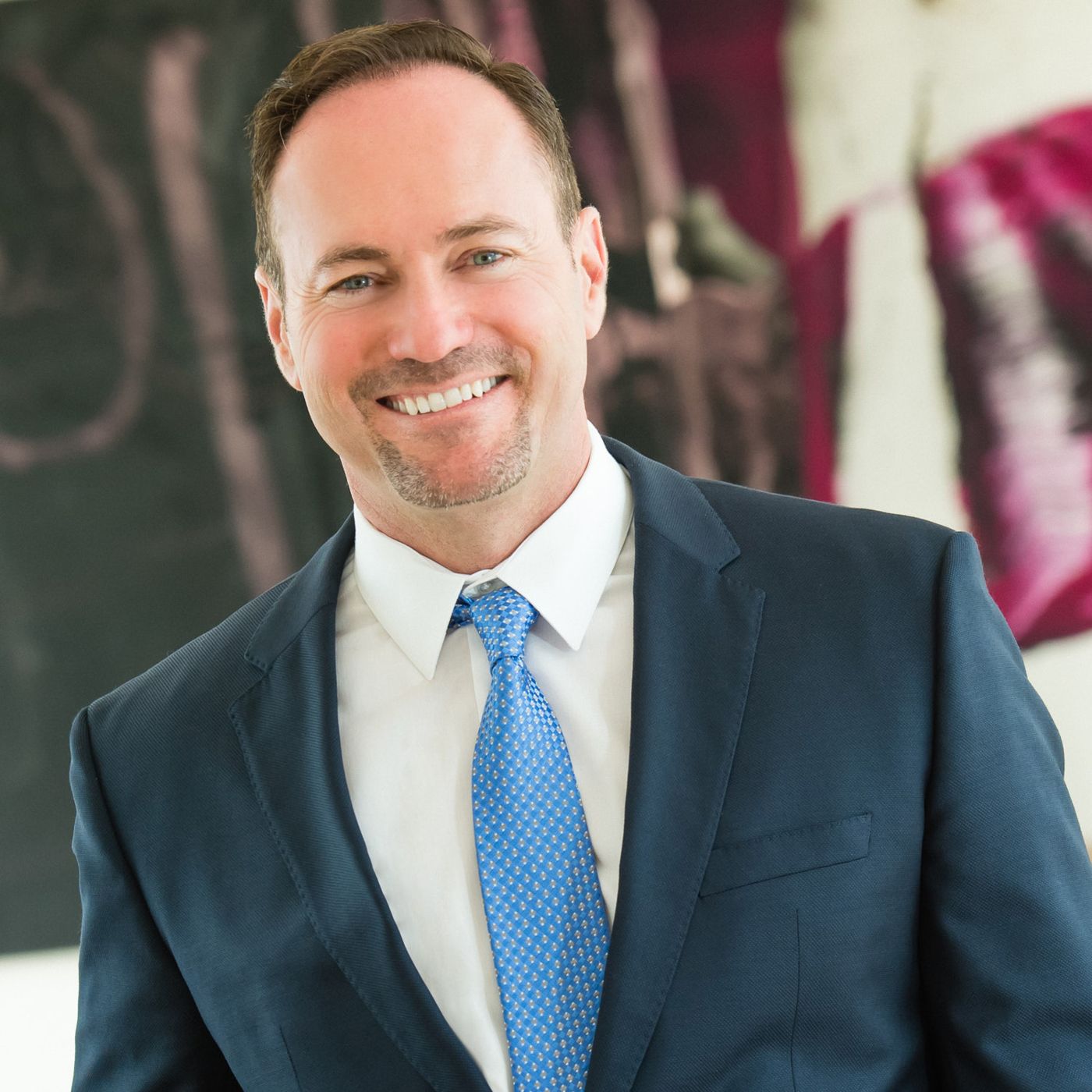 Corporate headshot in a blue suit